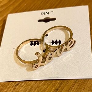 Love double finger ring on gold tone band new on card size 8 at “e”, 9 at “L”